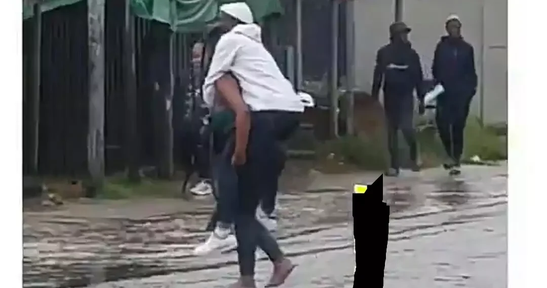 Lady spotted carrying her boyfriend on her back to cross dirty water(Video) 1 Lady spotted carrying her boyfriend on her back to cross dirty water(Video)