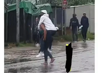 Lady spotted carrying her boyfriend on her back to cross dirty water(Video)